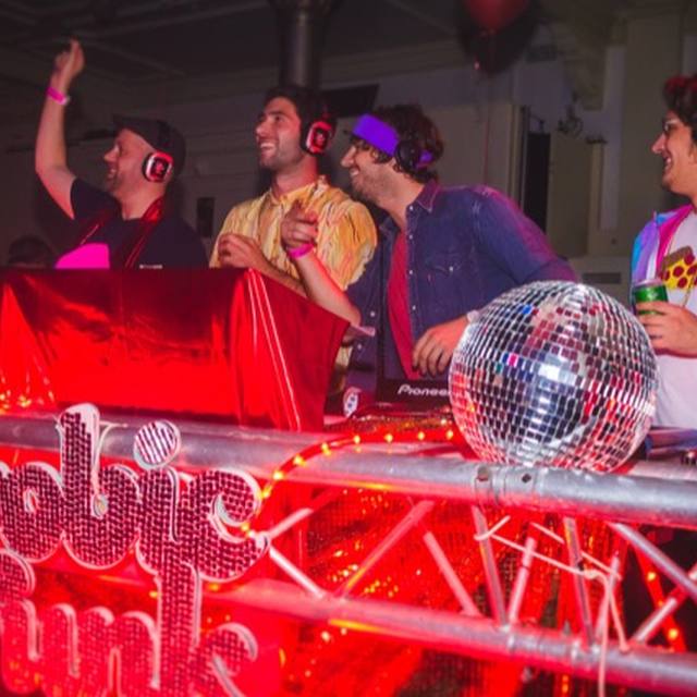 DJ booth with a disco ball and the crew cheering